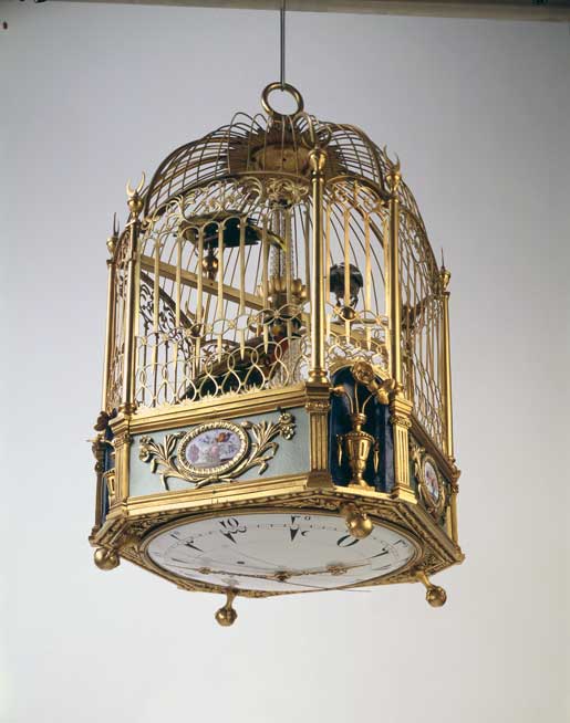 Singvogelkäfig mit Uhr und Serinette.